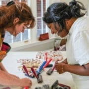 Two participants working on block printing during a community art workshop